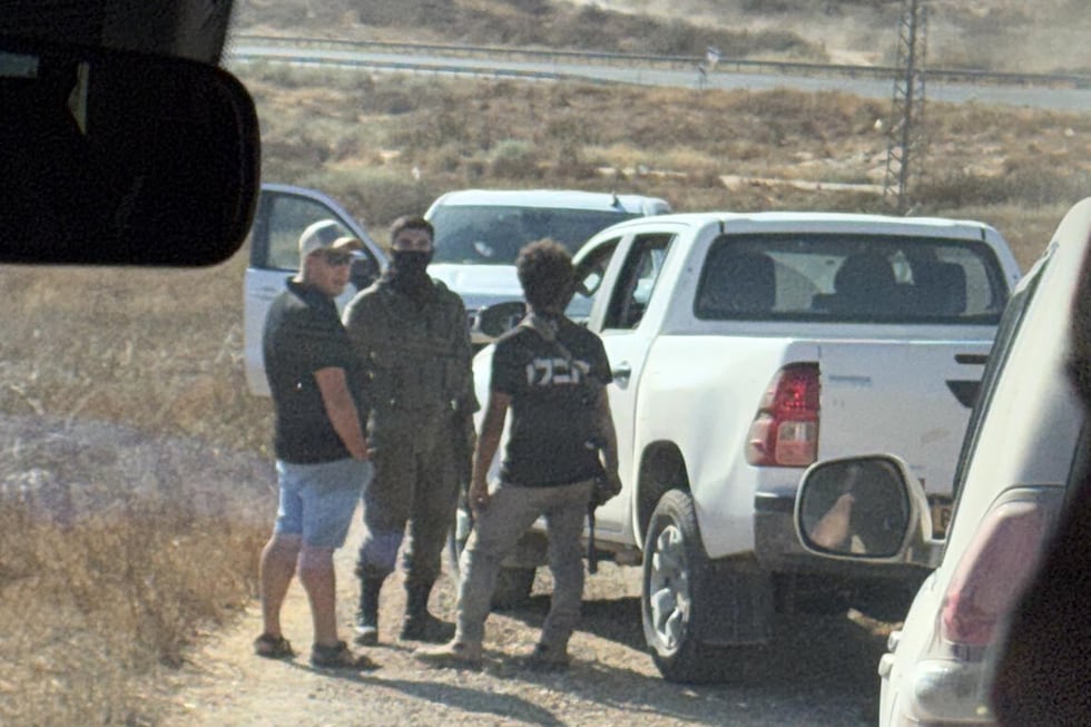In this photo provided by Cameron Kasky, armed men block the road, stopping vehicles...