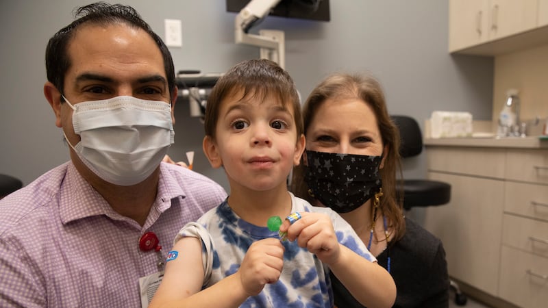 Dr. Barry Diener and Ilana Diener hold their son, Hudson, 3, during an appointment for a...